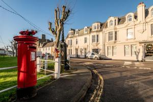 a red post box sitting on the side of a street at The Crow's Nest - Elie in Elie