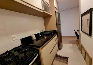 a kitchen with a sink and a stove top oven at Gramado Loft 105 in Gramado