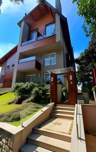 a house with a staircase leading up to the front door at Gramado Loft 105 in Gramado