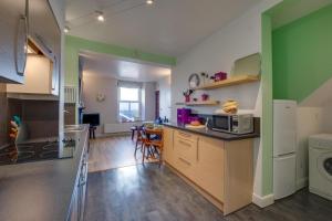 a kitchen with green walls and a counter with a microwave at 1 Bed in Mumbles oc-hh1205 in The Mumbles