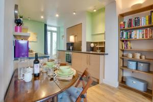 a kitchen with a wooden table with a bottle of wine at 1 Bed in Mumbles oc-hh1205 in The Mumbles