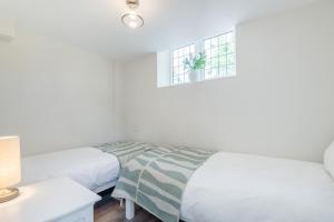 ein weißes Schlafzimmer mit zwei Betten und einem Fenster in der Unterkunft 2 Bed in Kemble oc-t32197 in Kemble