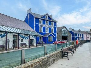 een blauw gebouw met bankjes voor een waterpartij bij 3 Bed in Cellan 86506 in Cellan