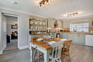 eine Küche mit einem Holztisch und Stühlen in einem Zimmer in der Unterkunft 2 Bed in Gimingham oc-h27869 in Trimingham