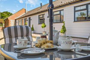 ein Glastisch mit Teetassen und Tellern darauf in der Unterkunft 2 Bed in Gimingham oc-h27869 in Trimingham