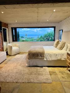 a bedroom with a large bed and a large window at 007 Loft in Mossel Bay