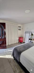 una camera da letto con un letto grande e una sedia rossa di Chalé Valen a Rio de Janeiro