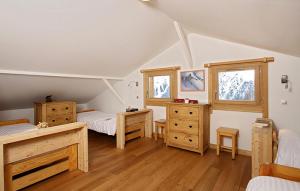 レ・デュー・アルプにあるOdalys Chalet La Muzelleの屋根裏のベッドルーム(ベッド2台、木製家具付)