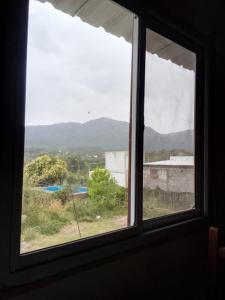 ein Fenster mit Blick auf ein Feld und Berge in der Unterkunft Los patos in Capilla del Monte