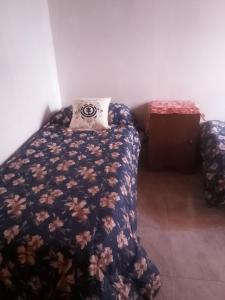 ein Schlafzimmer mit einem Bett und einem Kissen darauf in der Unterkunft Los patos in Capilla del Monte