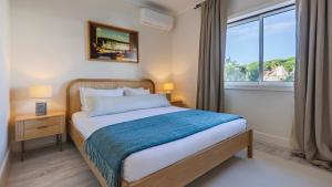 En eller flere senge i et værelse på Estoril Upscale Apartment with Pool by LovelyStay