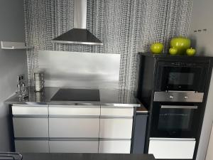 een keuken met een kookplaat, een oven en een magnetron bij Le refuge de Villeroux in Vaux-sur-Sûre