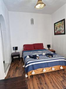 ein Schlafzimmer mit einem Bett mit einer blau-weißen gestreiften Decke in der Unterkunft le grand atlas in Mirleft