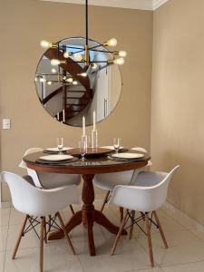 une salle à manger avec une table et un lustre dans l'établissement Linda Cobertura Pitangueiras, à Guarujá