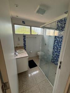 une salle de bain avec douche et lavabo dans l'établissement Linda Cobertura Pitangueiras, à Guarujá