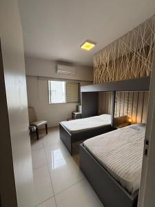 une chambre d'hôtel avec deux lits et une fenêtre dans l'établissement Linda Cobertura Pitangueiras, à Guarujá