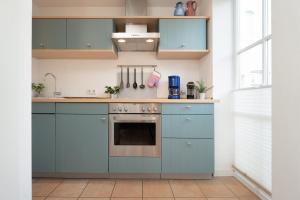 una cucina con armadi blu e forno di Räucherhäuschen a Fehmarn