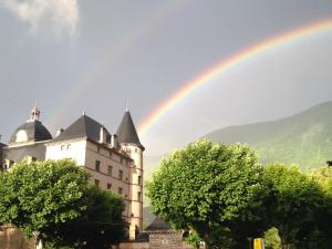 a rainbow in the sky above a castle at Hotel Sandra in Vizille