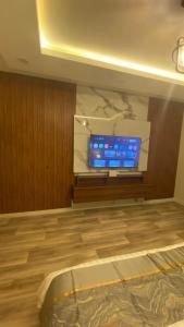 Zimmer mit einem Flachbild-TV an der Wand in der Unterkunft روف جازان ذات التصميم الفندقي in Dschāzān