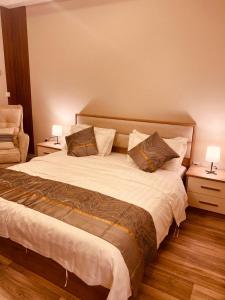 ein Schlafzimmer mit einem großen Bett mit zwei Tischen und zwei Lampen in der Unterkunft روف جازان ذات التصميم الفندقي in Dschāzān