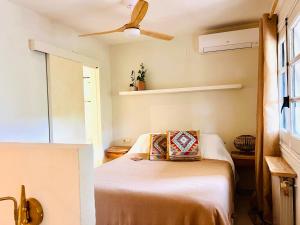 ein Schlafzimmer mit Bett und Deckenventilator in der Unterkunft Back to La Tierra, natural finca in Mijas in Mijas