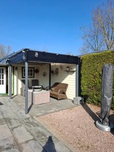 un padiglione con un divano e una panca al suo interno di CHALET36 in GROU a Grou