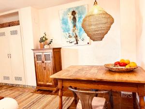 een eetkamer met een houten tafel en een fruitschaal bij Back to La Tierra, natural finca in Mijas in Mijas +23 foto's