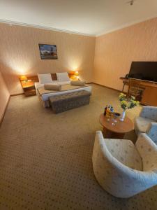 乌尔根奇Khorezm Palace Hotel的一间宽敞的酒店房间，里面有两张床和一架钢琴