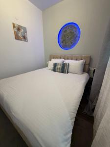 ein Schlafzimmer mit einem großen Bett und einem blauen Teller an der Wand in der Unterkunft Qulity Hayati Alexandroupolis in Alexandroupoli