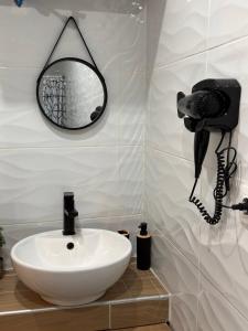 ein Badezimmer mit Waschbecken und Telefon an der Wand in der Unterkunft Qulity Hayati Alexandroupolis in Alexandroupoli + 10 Fotos