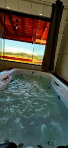 una grande vasca da bagno in una stanza con finestra di Oasis na montanha a Bueno Brandão
