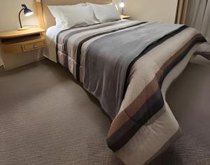 una camera con un grande letto e un comodino di Residencial Seidl Gramado a Gramado