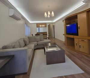 un soggiorno con un divano e una TV di Residencial Seidl Gramado a Gramado