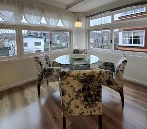 una sala da pranzo con tavolo e sedie in vetro di Residencial Seidl Gramado a Gramado