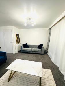 een woonkamer met een bank en een salontafel bij The Pheasant - Luxury 3-bedroom Apartment in Dartford in Dartford