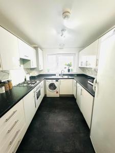 een keuken met witte kasten, een spoelbak en een vaatwasser bij The Pheasant - Luxury 3-bedroom Apartment in Dartford in Dartford +26 foto's