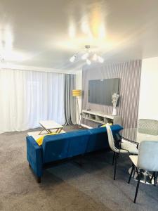 een woonkamer met een blauw bed en een televisie bij The Pheasant - Luxury 3-bedroom Apartment in Dartford in Dartford
