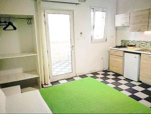 een keuken met een groen tapijt op de vloer bij Casa Lu Salentu - Monolocale superior in Torre Lapillo