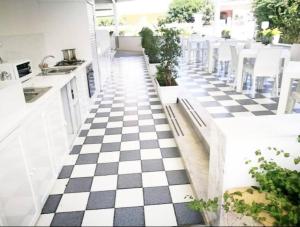 een keuken met een zwart-wit geblokte vloer bij Casa Lu Salentu - Monolocale superior in Torre Lapillo