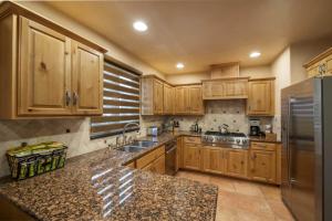 eine Küche mit Holzschränken und einem Edelstahlkühlschrank in der Unterkunft Santa Fe Downtown Corner Courtyard @ El Corazon de Santa Fe in Santa Fe + 8 Fotos