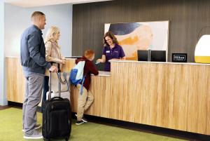 a group of people standing at a reception counter at Spark By Hilton Seattle Airport in Seattle