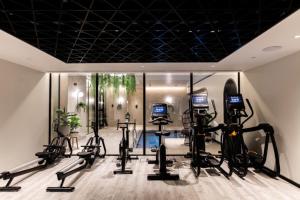 een sportschool met loopbanden en crosstrainers bij City View Apartment with Pool in Manchester