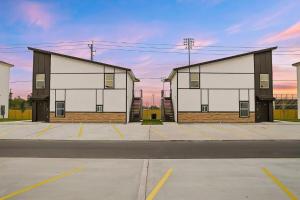 two large white buildings in a parking lot at Executive Comfort Suite in Weslaco