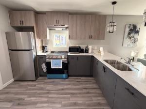 a kitchen with a refrigerator stove and a sink at Executive Comfort Suite in Weslaco