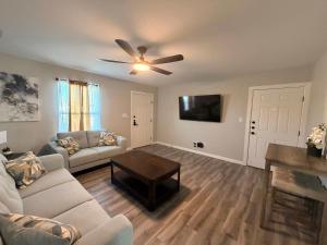 a living room with a couch and a ceiling fan at Executive Comfort Suite in Weslaco