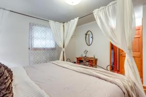 Schlafzimmer mit einem Bett mit weißen Vorhängen in der Unterkunft 1 Mi to Dtwn Mountain View Home with Deck in Mountain View