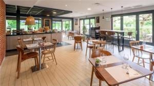 a restaurant with tables and chairs and a bar at Campanile NATURE - Toulouse Nord L'Union in LʼUnion
