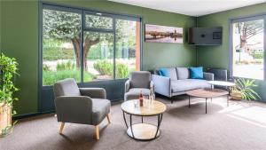 a living room with chairs and a couch and a table at Campanile NATURE - Toulouse Nord L'Union in LʼUnion