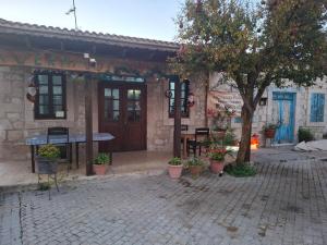 a building with a table and a tree in front of it at Simou Apartment in Simou