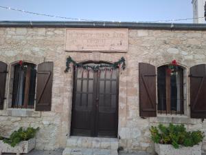 a stone building with a door and a sign on it at Simou Apartment in Simou